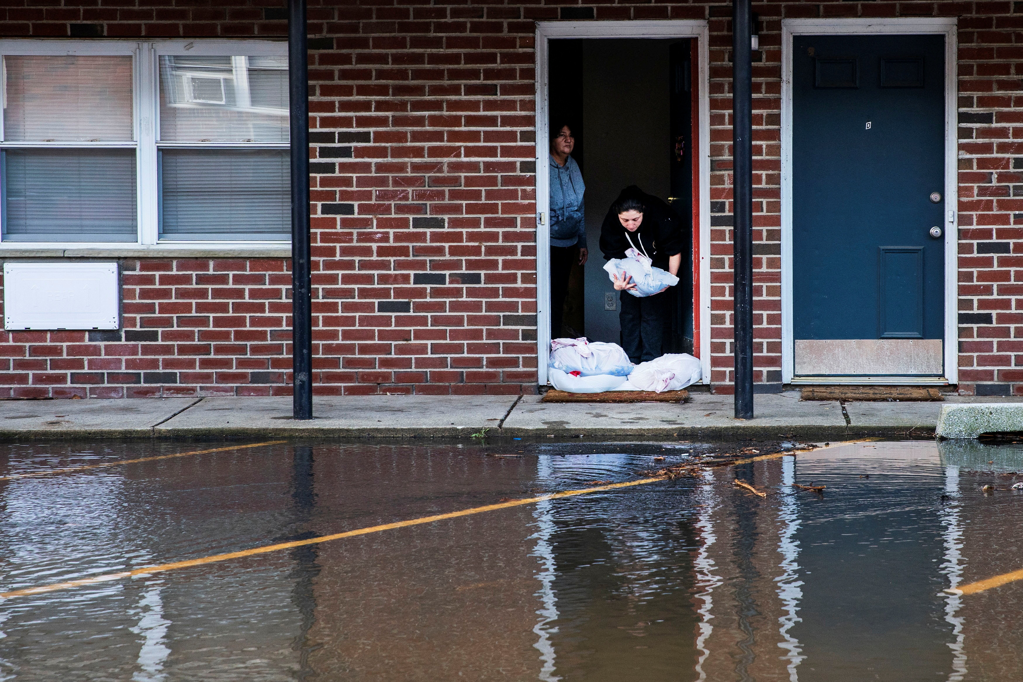Residents block the entrance of their home while their street get flooded during the pass of a winter storm in Lodi, New Jersey, U.S., January 10, 2024. REUTERS/Eduardo Munoz