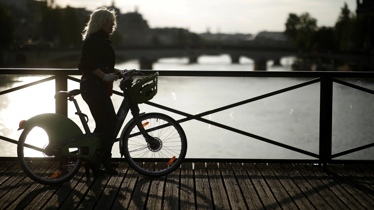 FILE PHOTO: A woman rides a bike at the Pont des Arts bridge during the outbreak of the coronavirus disease (COVID-19) in Paris, France, May 2, 2020. REUTERS/Benoit Tessier/File Photo