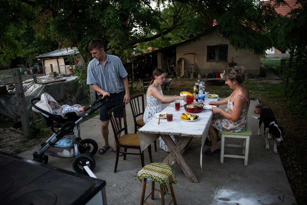 Mihaly Pogany, 29, his wife Petra Pogany-Bago, 24, their son Mihaly Pogany and Petra's mother Marsa Irma have dinner at their farm near Kecskemet, Hungary, July 16, 2023.  REUTERS/Marton Monus