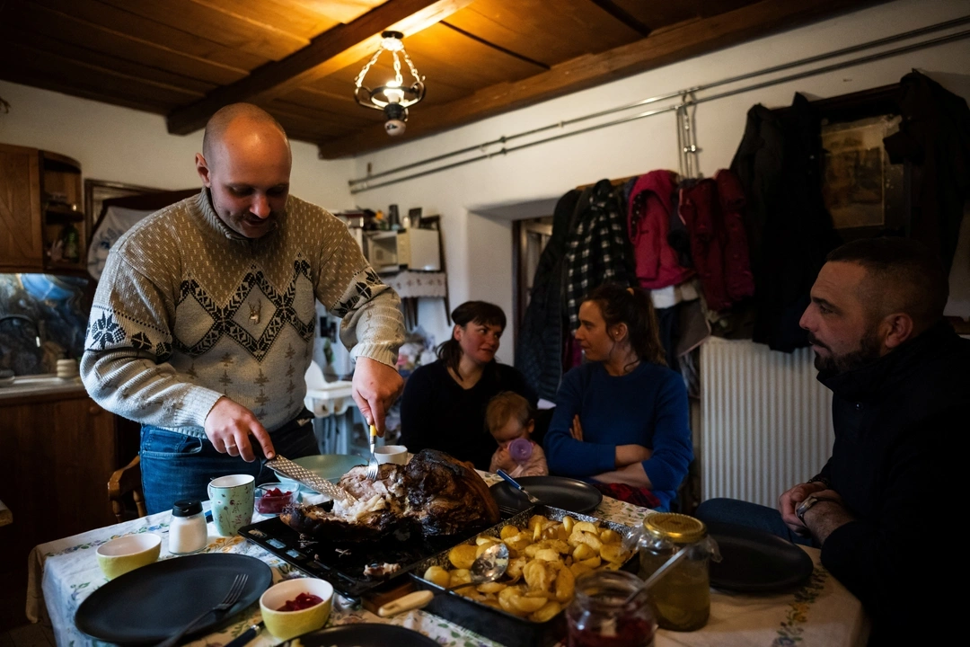 Laszlo Kemencei, 28, with his wife Cintia Mnyere, 31, their daughter Baroka, and their friends Krisztian Kisjuhasz, 41, and his partner Zsanett Homoki, 34, have lunch at Kemencei's farm near Ladanybene, Hungary, March 7, 2024.  REUTERS/Marton Monus