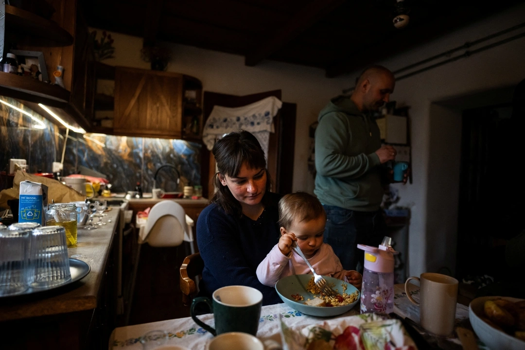 Laszlo Kemencei, 28, his wife Cintia Mnyere, 31, and their daughter Boroka have breakfast at their farm near Ladanybene, Hungary, March 7, 2024. REUTERS/Marton Monus