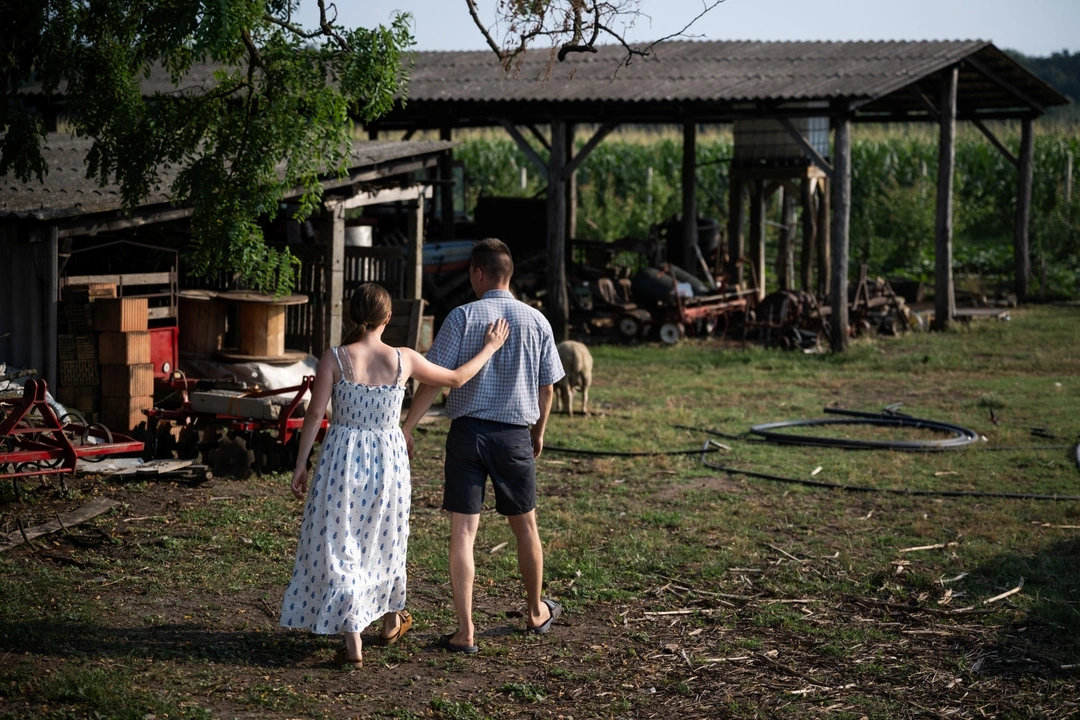 Mihaly Pogany, 29, and his wife Petra Pogany-Bago, 24, walk on their farm near Kecskemet, Hungary, July 16, 2023. Laszlo Kemencei, 28, who also lives sustainably, estimates there are around 1,000 families trying to embrace some form of sustainability, either alone or as part of informal barter arrangements, or as part of more structured eco-villages. REUTERS/Marton Monus