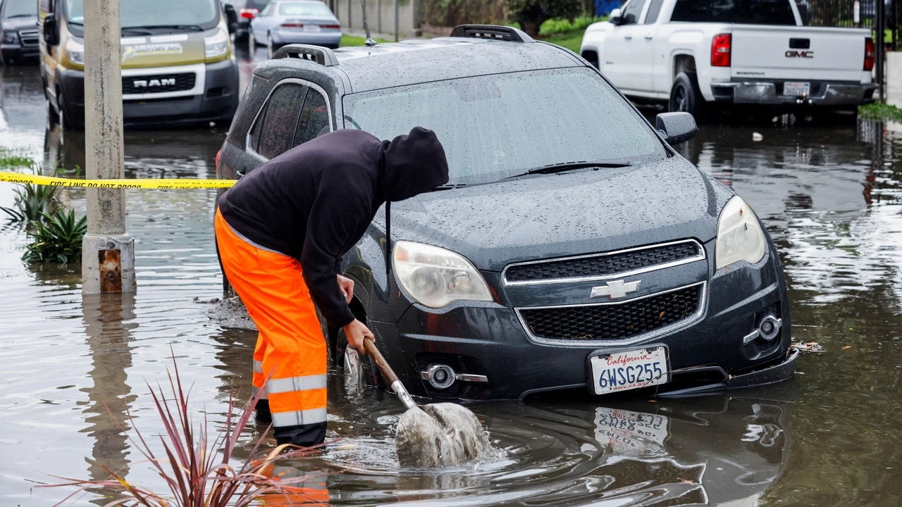 A person works to drain the gutter, in Harbor City, Los Angeles, California, U.S. February 1, 2024. REUTERS/Carlin Stiehl