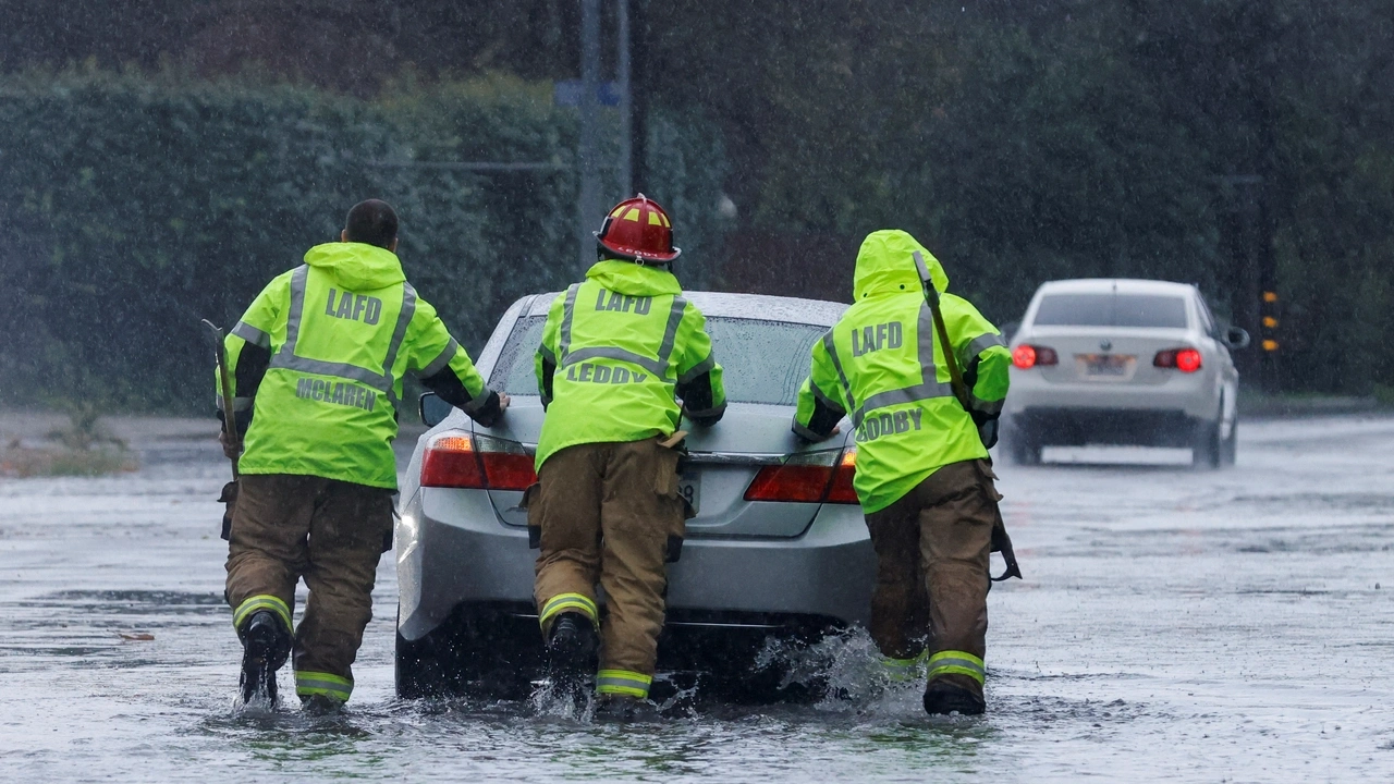 Firemen aid a vehicle through flood water in Tarzana, in the San Fernando Valley region of Los Angeles, California, U.S. February 1, 2024. REUTERS/Carlin Stiehl