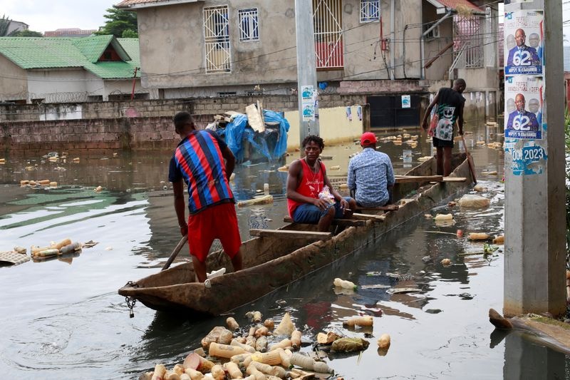 People use a boat to move after the Congo River rises to its highest level, causing flooding in Kinshasa, Democratic Republic of Congo January 10, 2024.REUTERS/Justin Makangara