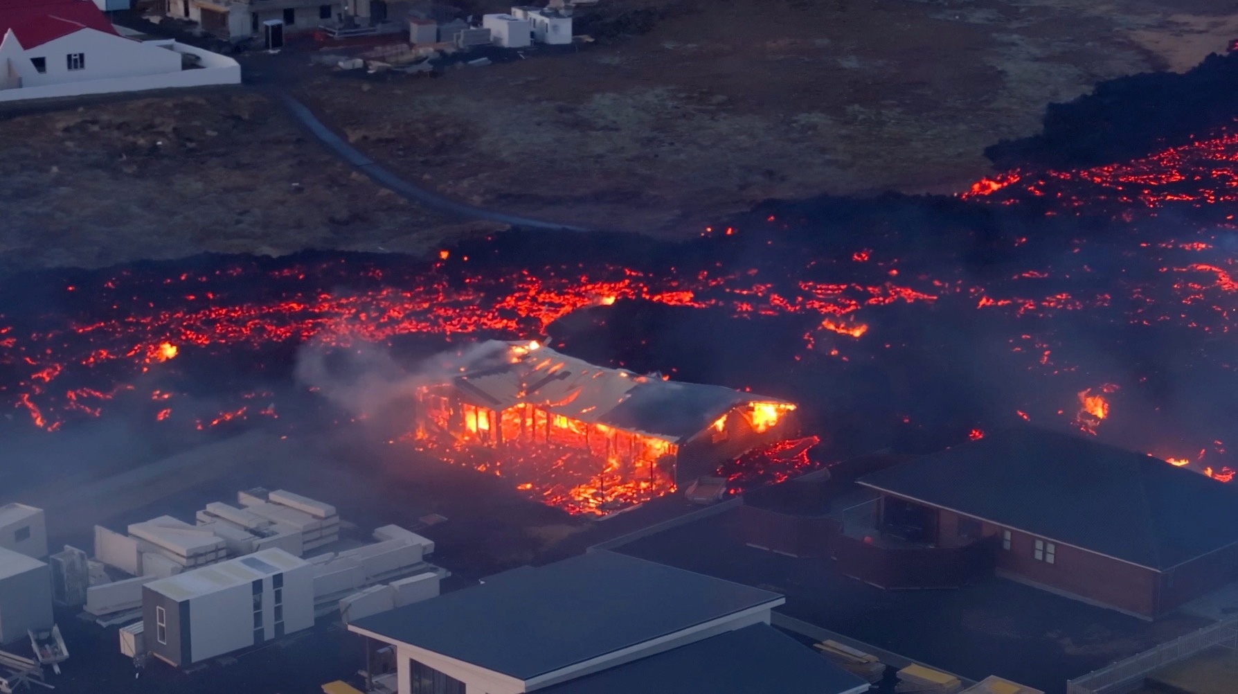 Lava flows from a volcano as houses burn in Grindavik, Iceland, January 14, 2024, in this screen grab obtained from a social media video. Bjorn Steinbekk/@bsteinbekk via Instagram/via REUTERS
