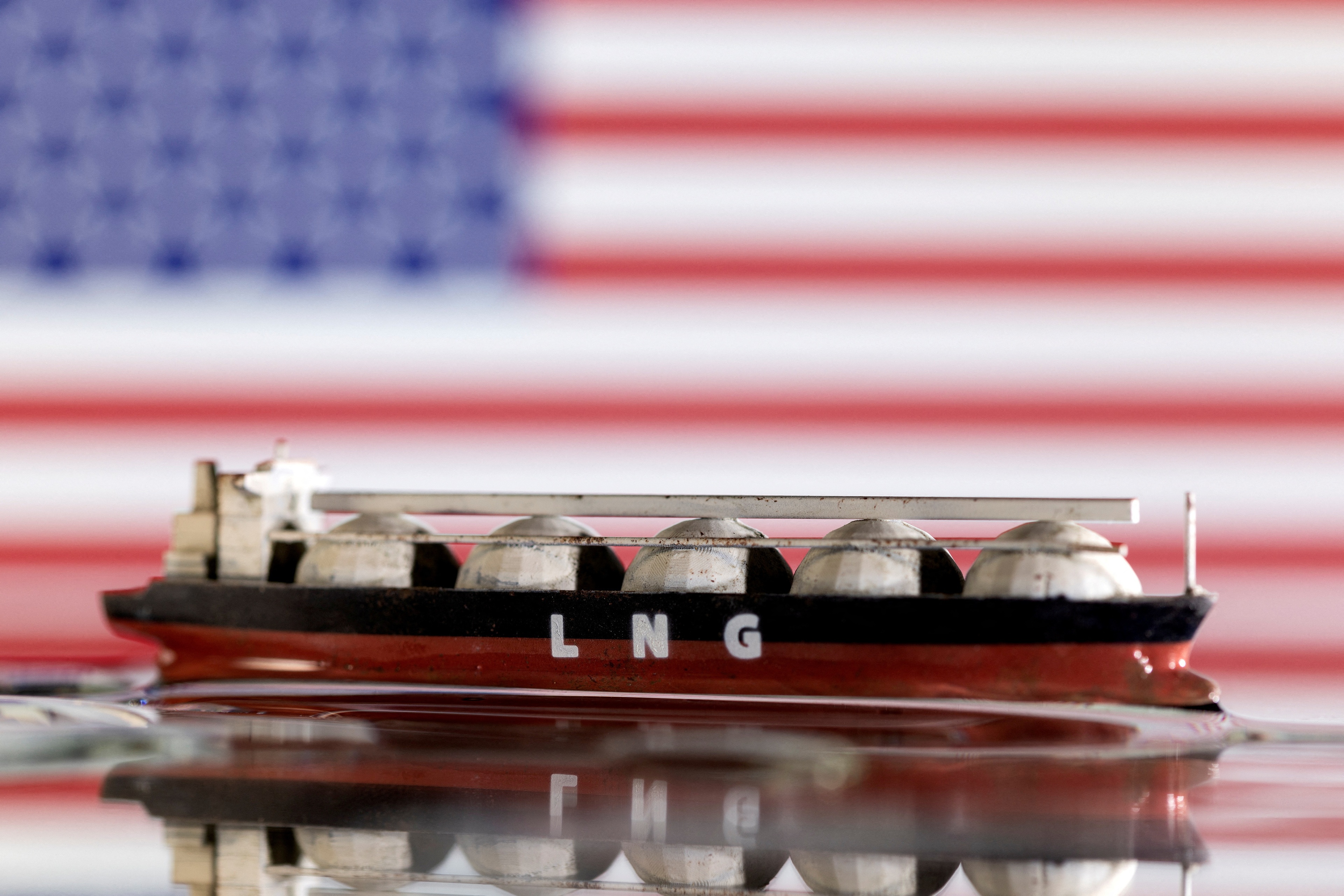 FILE PHOTO: Model of LNG tanker is seen in front of the U.S. flag in this illustration taken May 19, 2022. REUTERS/Dado Ruvic/Illustration/File Photo