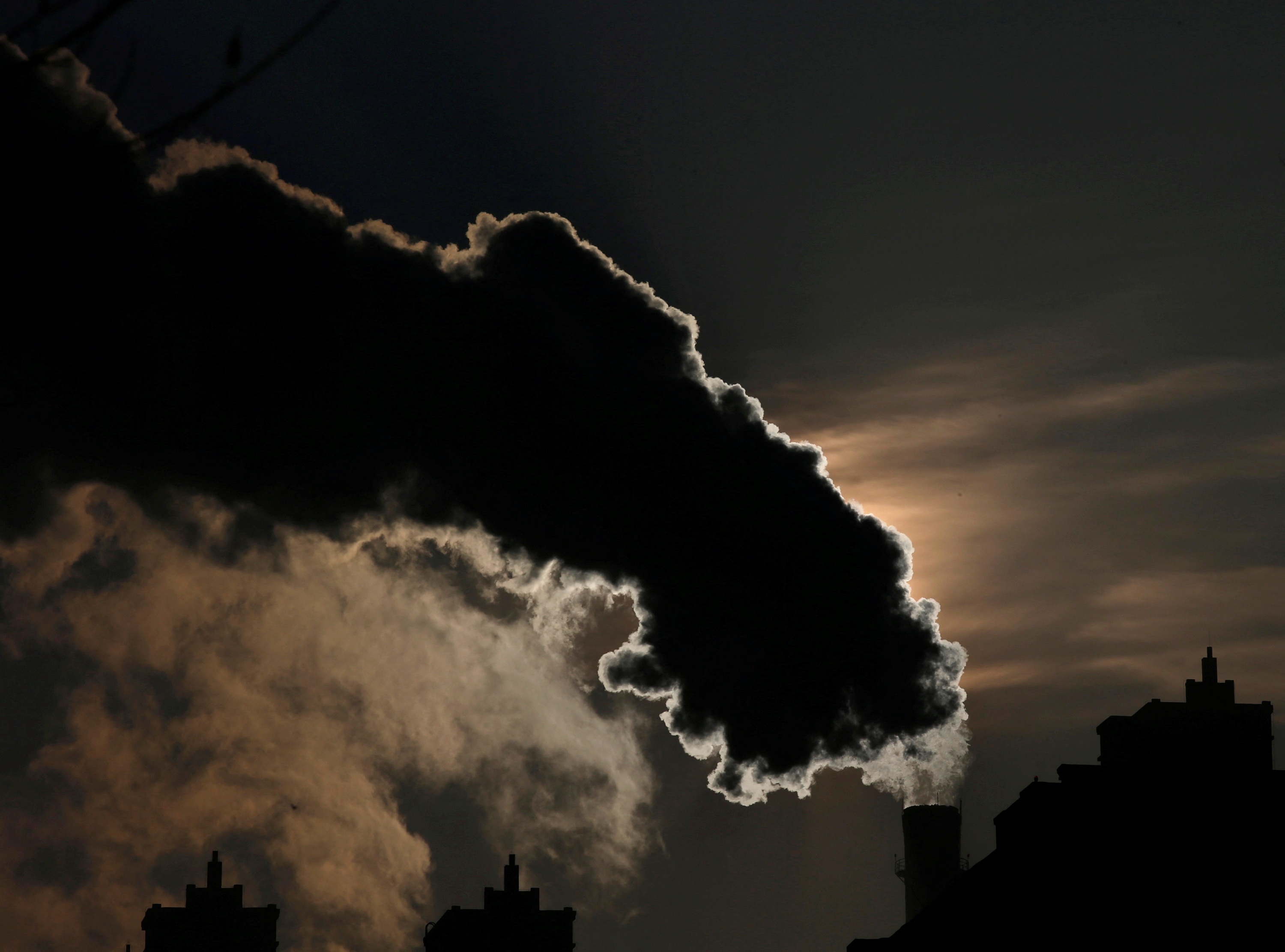 FILE PHOTO: Smoke from a chimney is silhouetted against the rising sun in the northern city of Harbin, Heilongjiang province, January 6, 2014.  REUTERS/Kim Kyung-Hoon/File Photo