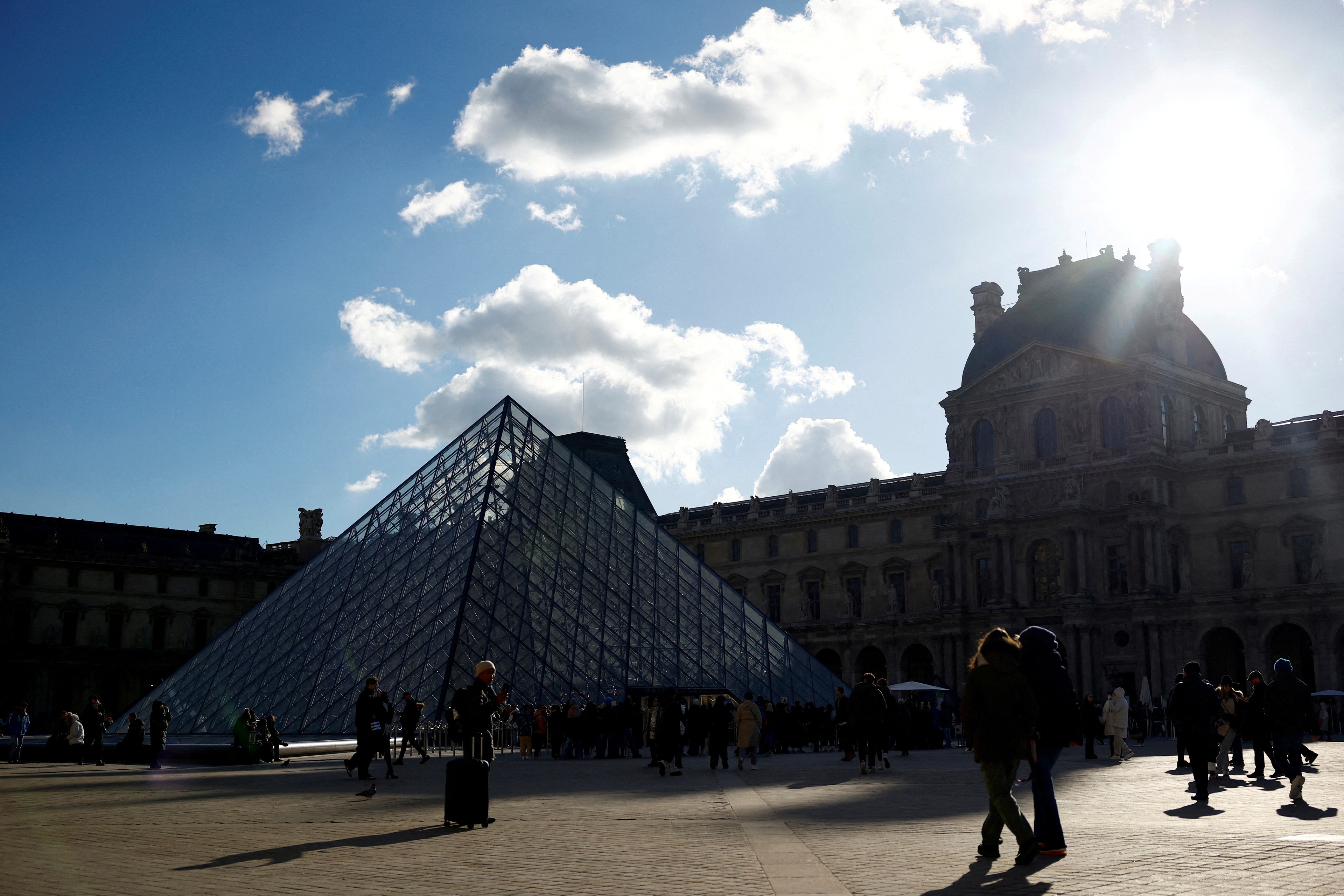 FILE PHOTO: Tourists walk past the glass Pyramid of the Louvre Museum in Paris, France, January 15, 2024. REUTERS/Sarah Meyssonnier/File Photo