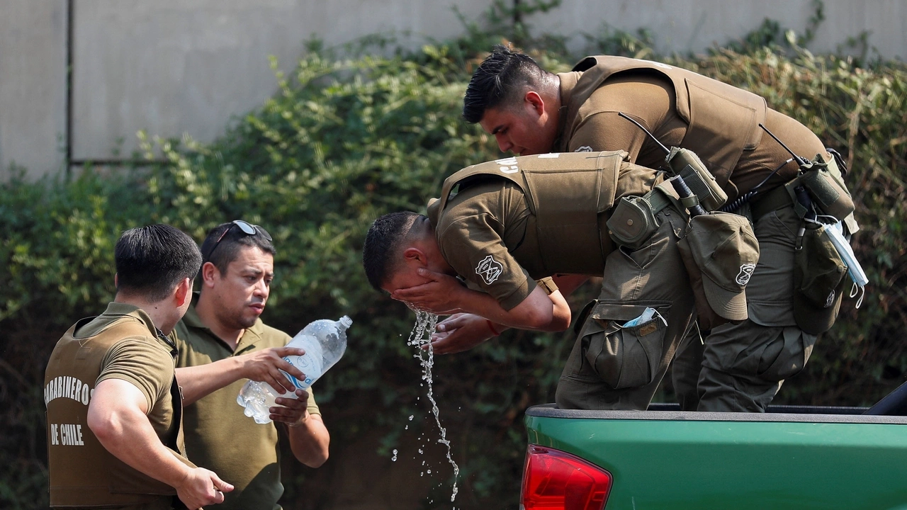 Police officers drink water and refresh themselves amid the spread of wildfires in Vina del Mar, Chile, February 3, 2024. REUTERS/Rodrigo Garrido