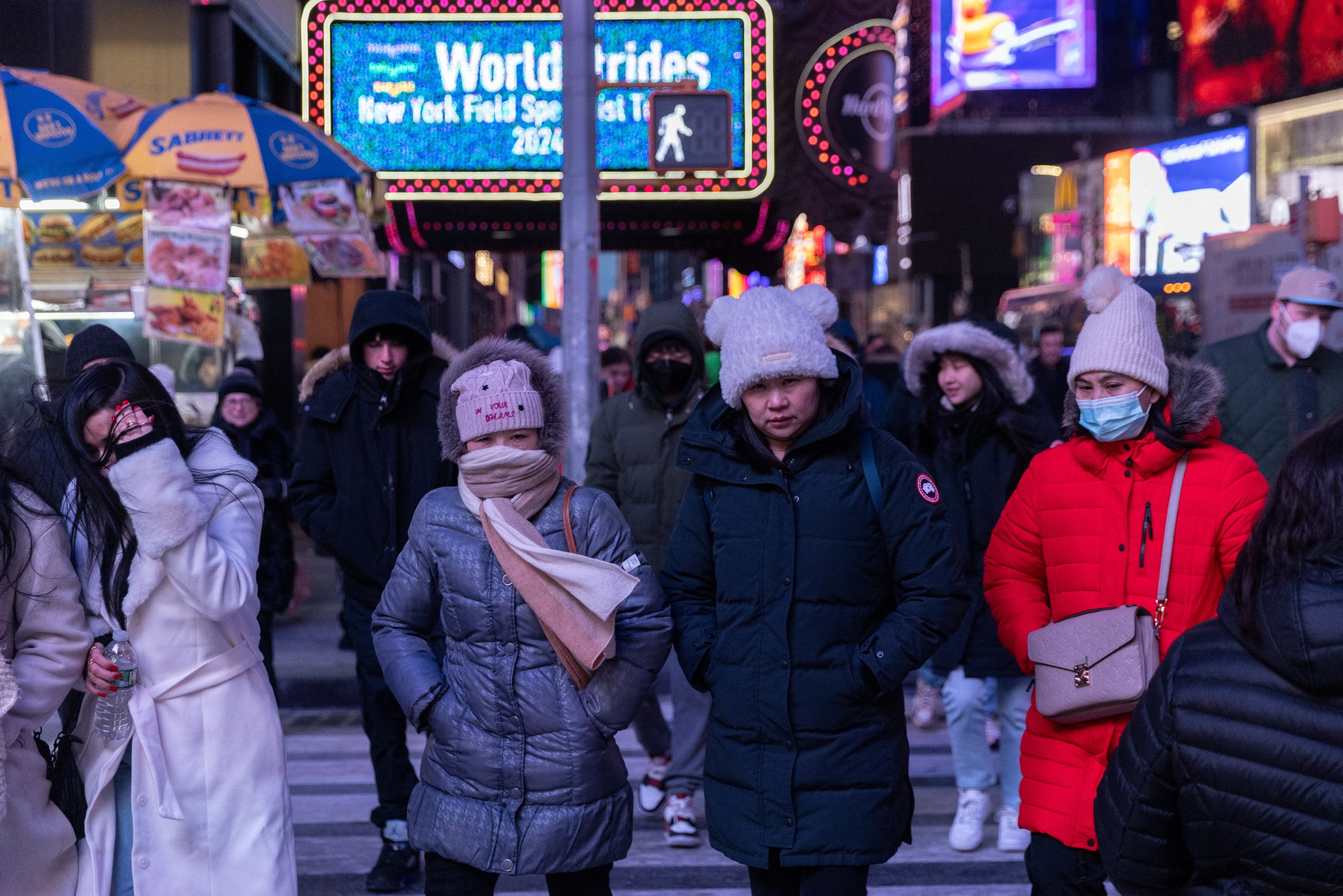 People walk in Times Square during cold weather in New York City, U.S., January 20, 2024. REUTERS/Jeenah Moon