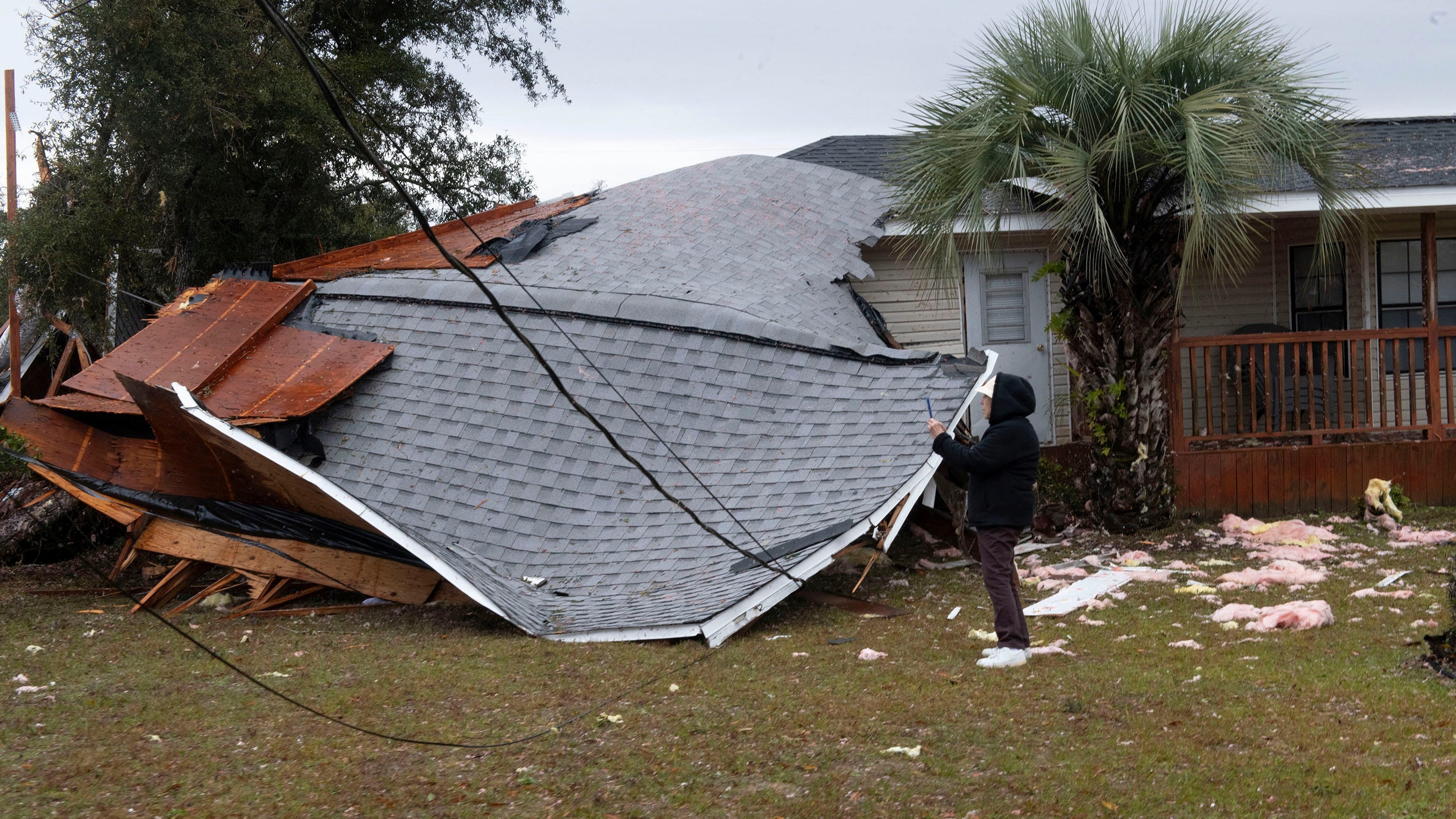 A resident checks a collapsed roof after a line of storms roared through the area of Perdido Key near Pensacola, Florida, U.S. January 9, 2024.  Tony Gilbertson/USA Today Network via REUTERS