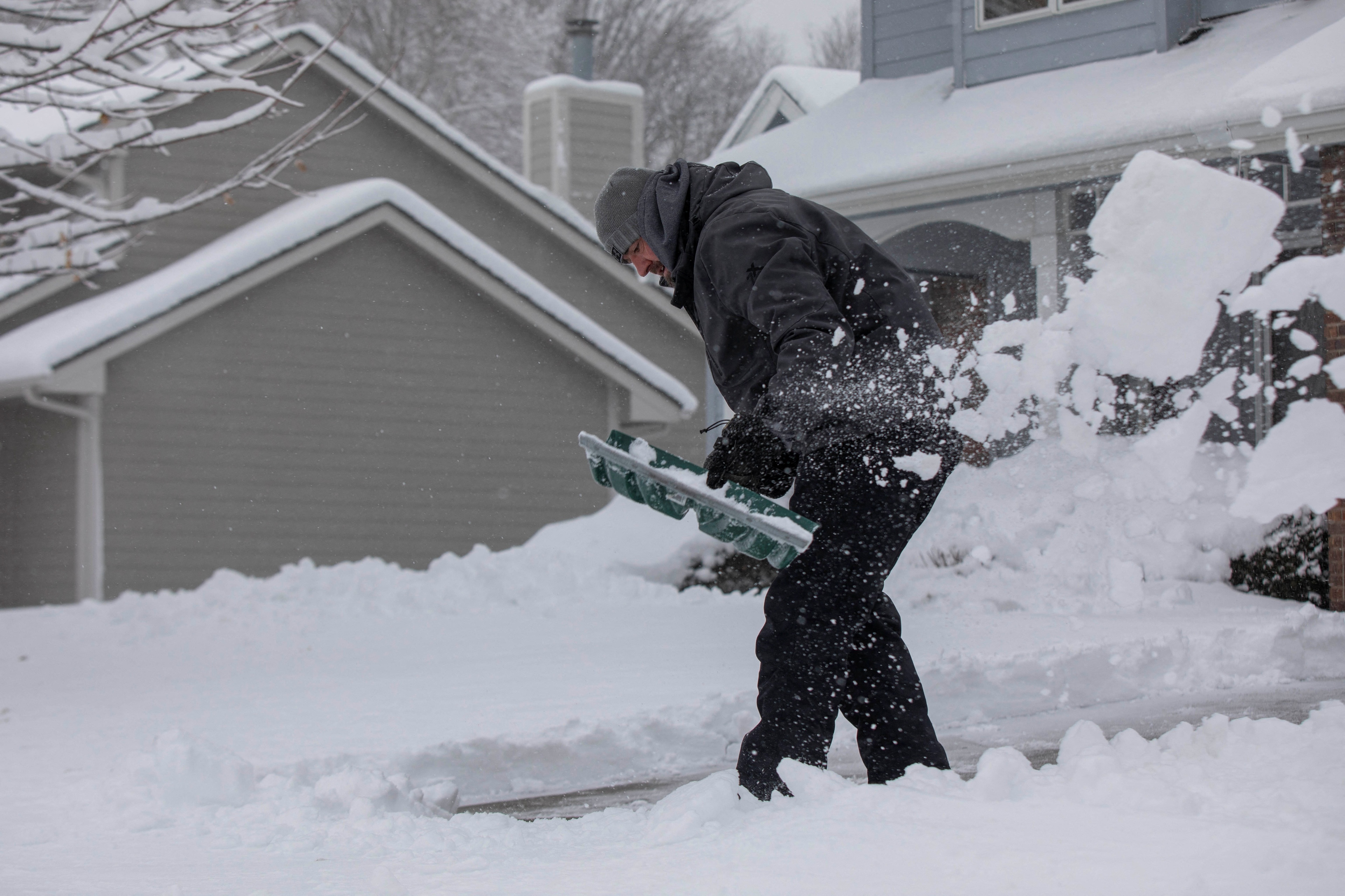 Zach Brobst shovels in his driveway after a snowstorm left several inches of snow in Clive, Iowa, U.S., January 9, 2024. REUTERS/Alyssa Pointer