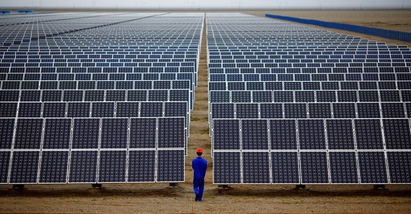 FILE PHOTO: A worker inspects solar panels at a solar Dunhuang, 950km (590 miles) northwest of Lanzhou, Gansu Province September 16, 2013. REUTERS/Carlos Barria