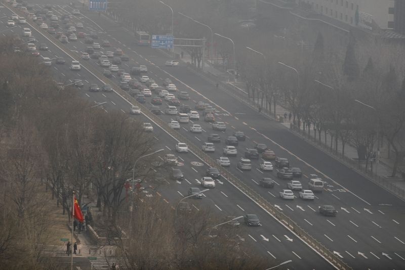 FILE PHOTO: Cars move on a street on a polluted day in Beijing, China March 7, 2023. REUTERS/Tingshu Wang