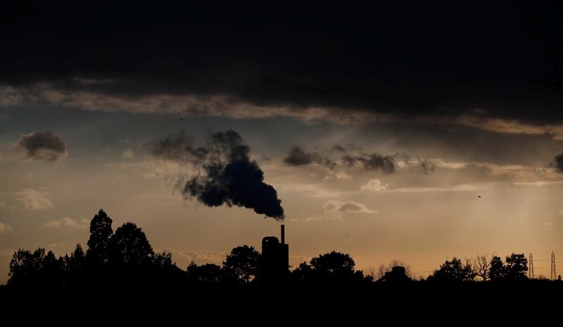 Smoke rises above a factory at sunset in Rugby, Britain February 10, 2021. REUTERS/Matthew Childs/File Photo