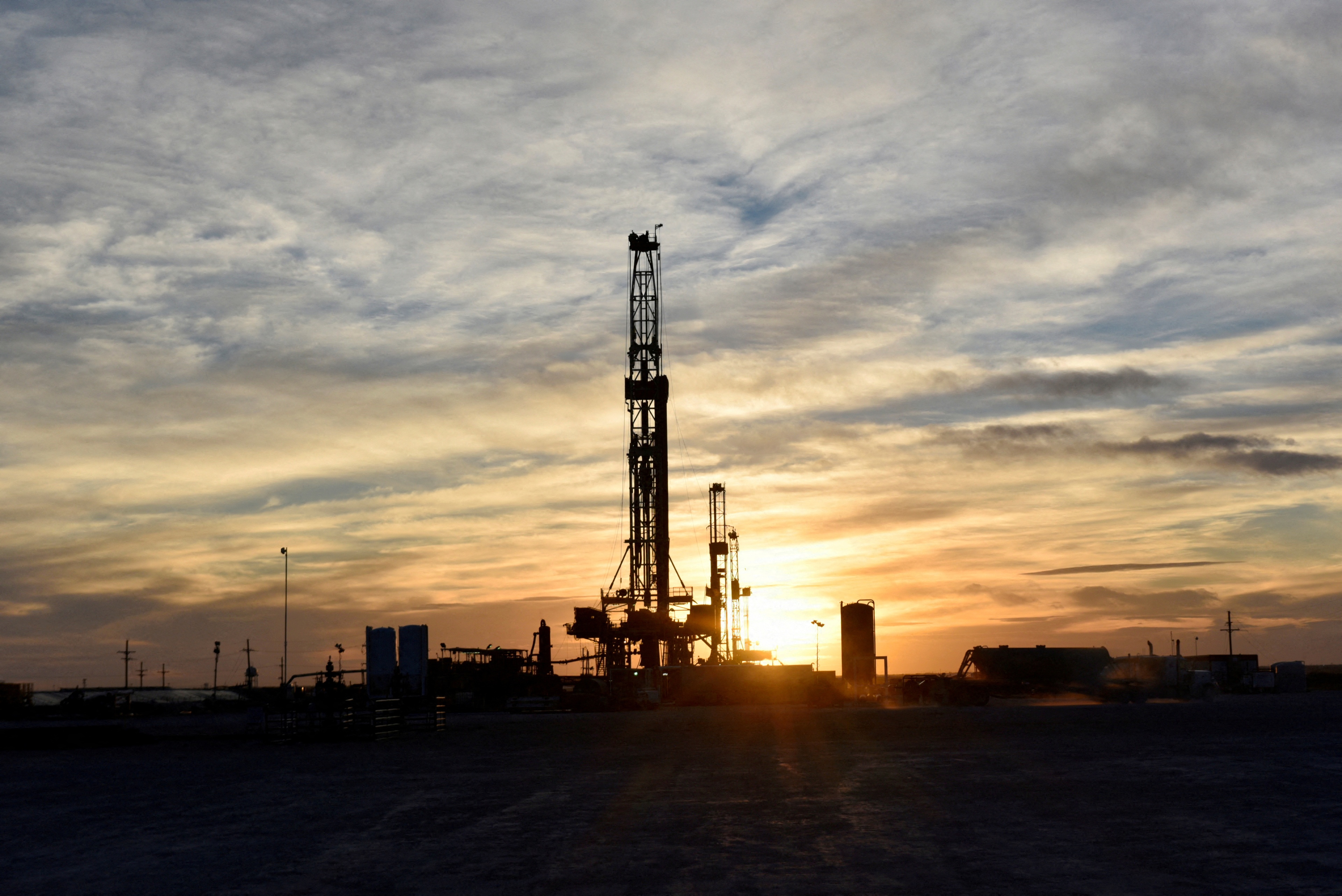 FILE PHOTO: Drilling rigs operate at sunset in Midland, Texas, U.S., February 13, 2019. Picture taken February 13, 2019. REUTERS/Nick Oxford/File Photo